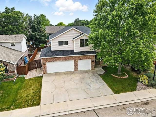 2078 Goldfinch Ct, Longmont, CO 80503 - view of front of house with an attached garage, concrete driveway, a shingled roof, and brick siding