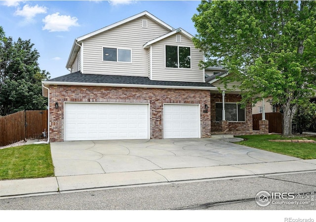 2078 Goldfinch Ct, Longmont, CO 80503 - traditional-style house with driveway, an attached garage, brick siding, and a shingled roof