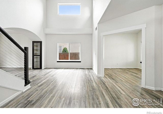 2078 Goldfinch Ct, Longmont, CO 80503 - foyer featuring arched walkways, stairs, plenty of natural light, wood finished floors, and a high ceiling