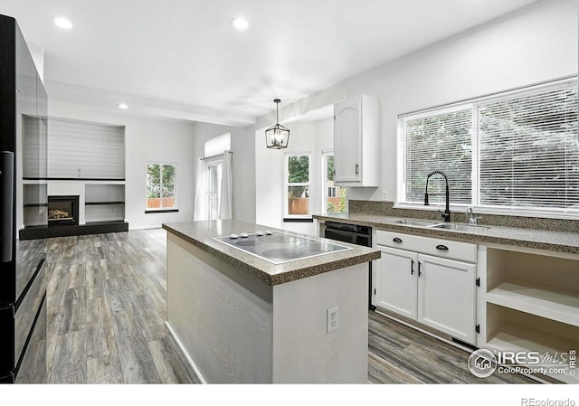 2078 Goldfinch Ct, Longmont, CO 80503 - kitchen featuring electric stovetop, dark countertops, wood finished floors, white cabinets, and a kitchen island