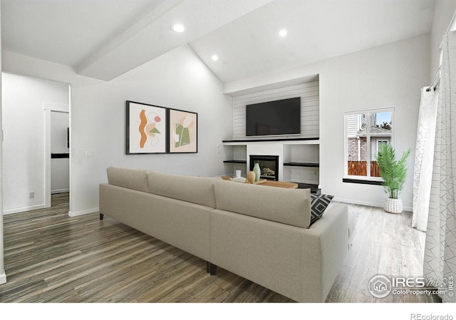 2078 Goldfinch Ct, Longmont, CO 80503 - living room featuring wood finished floors, a glass covered fireplace, recessed lighting, and vaulted ceiling