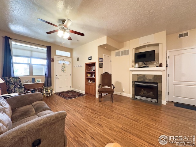 4101 Crittenton Ln Unit 102, Wellington, CO 80549 - living area with a textured ceiling, ceiling fan, a tile fireplace, and wood finished floors