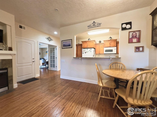 4101 Crittenton Ln Unit 102, Wellington, CO 80549 - dining room featuring dark wood-style floors, a textured ceiling, a fireplace, and recessed lighting