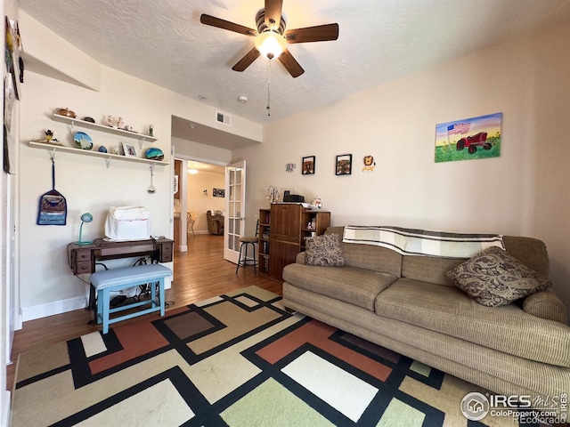 4101 Crittenton Ln Unit 102, Wellington, CO 80549 - living room featuring a ceiling fan, a textured ceiling, french doors, and wood finished floors