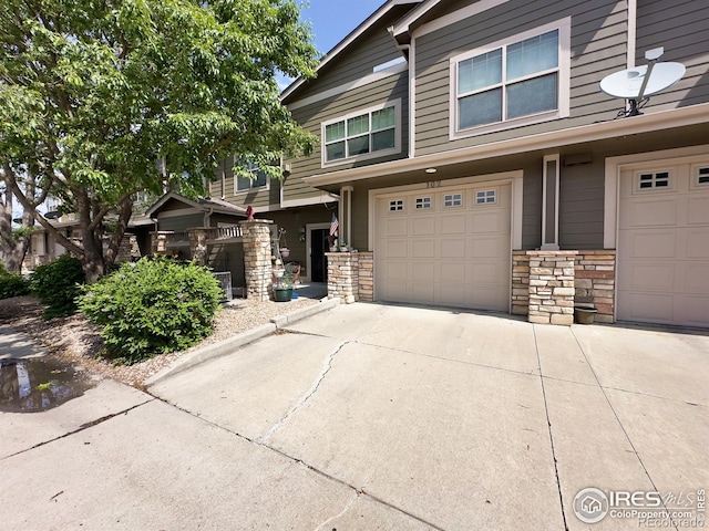 4101 Crittenton Ln Unit 102, Wellington, CO 80549 - view of front facade featuring concrete driveway, stone siding, and an attached garage