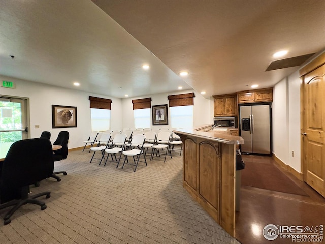 4101 Crittenton Ln Unit 102, Wellington, CO 80549 - kitchen featuring stainless steel appliances, dark carpet, recessed lighting, brown cabinetry, and a kitchen bar