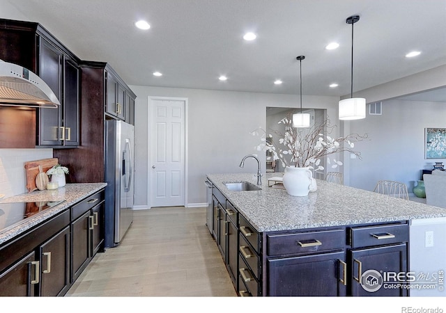 16021 Williams Pl, Broomfield, CO 80023 - kitchen featuring stainless steel appliances, recessed lighting, wall chimney exhaust hood, a kitchen island with sink, and light stone countertops