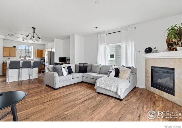 14700 E 104th Ave Unit 2605, Commerce City, CO 80022 - living room with light wood finished floors and a tiled fireplace