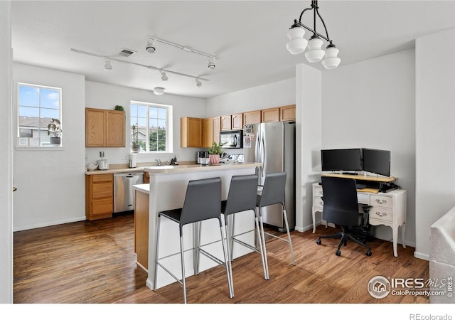 14700 E 104th Ave Unit 2605, Commerce City, CO 80022 - kitchen featuring stainless steel appliances, light countertops, wood finished floors, and track lighting