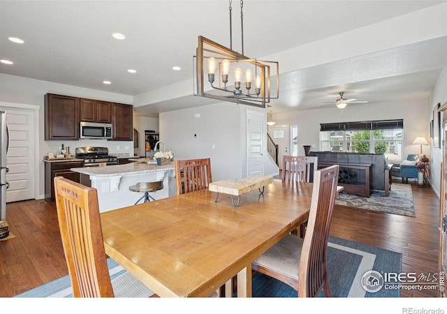 1325 Tipton St, Berthoud, CO 80513 - dining space with dark wood-type flooring, stairs, recessed lighting, ceiling fan, and a chandelier