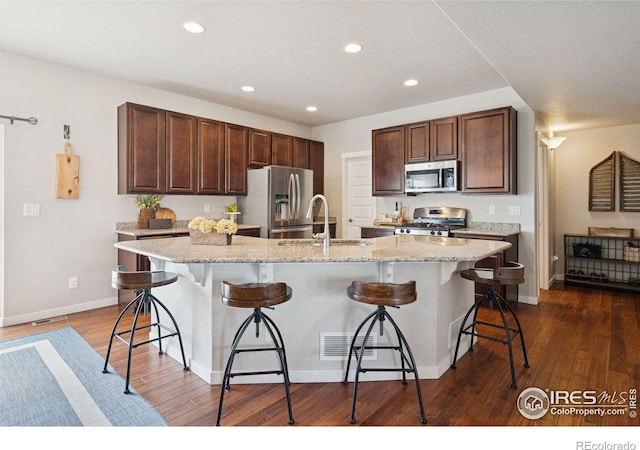 1325 Tipton St, Berthoud, CO 80513 - kitchen featuring appliances with stainless steel finishes, recessed lighting, dark wood-style flooring, a large island, and a breakfast bar area