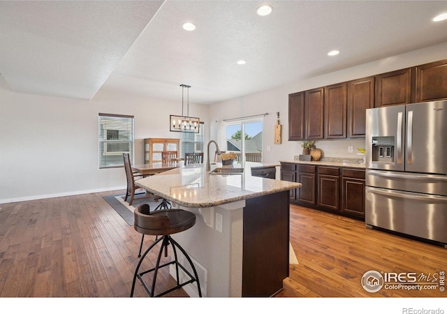 1325 Tipton St, Berthoud, CO 80513 - kitchen featuring stainless steel appliances, light wood-style flooring, a breakfast bar, a chandelier, and recessed lighting