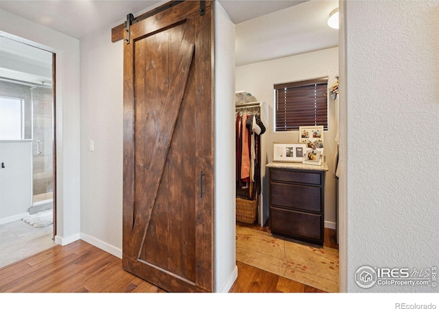 1325 Tipton St, Berthoud, CO 80513 - corridor featuring a barn door and light wood-type flooring
