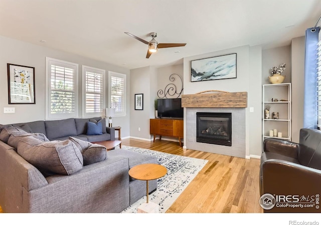 549 Jackson St, Lafayette, CO 80026 - living area with wood finished floors, a ceiling fan, and a tiled fireplace