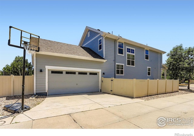 549 Jackson St, Lafayette, CO 80026 - back of house featuring an attached garage, driveway, and a gate
