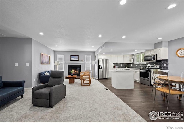 42 Scott Dr S, Broomfield, CO 80020 - living room featuring dark wood-style floors, recessed lighting, and a glass covered fireplace