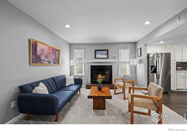42 Scott Dr S, Broomfield, CO 80020 - living room featuring recessed lighting, a glass covered fireplace, dark wood-style floors, a textured ceiling, and a textured wall