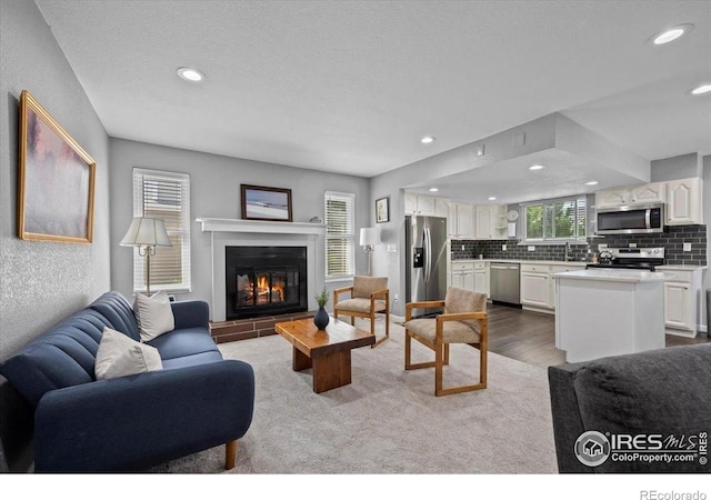 42 Scott Dr S, Broomfield, CO 80020 - living room featuring recessed lighting, a glass covered fireplace, and dark wood-style flooring