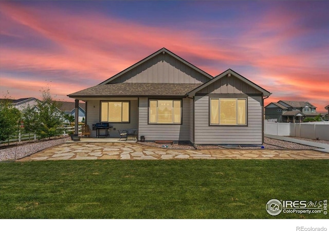 1520 Lake Vista Way, Severance, CO 80550 - back of property at dusk featuring a patio, board and batten siding, and roof with shingles