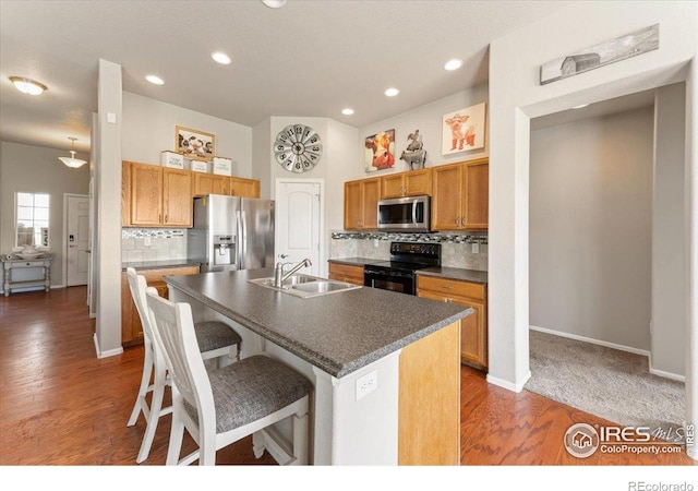 1520 Lake Vista Way, Severance, CO 80550 - kitchen with appliances with stainless steel finishes, dark countertops, decorative backsplash, a breakfast bar, and recessed lighting