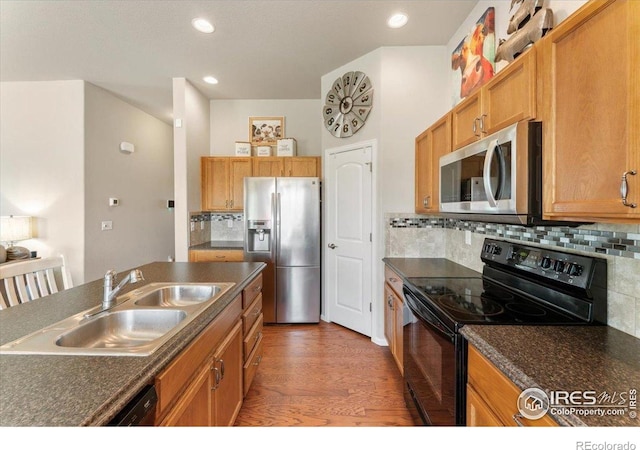 1520 Lake Vista Way, Severance, CO 80550 - kitchen featuring stainless steel appliances, dark countertops, wood finished floors, backsplash, and recessed lighting