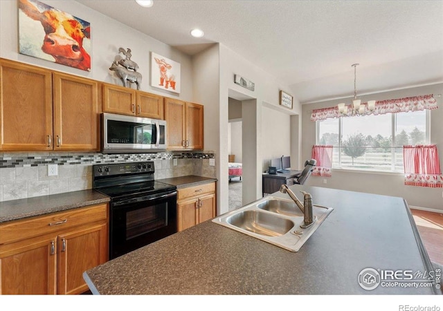 1520 Lake Vista Way, Severance, CO 80550 - kitchen with black electric range oven, stainless steel microwave, dark countertops, tasteful backsplash, and brown cabinets