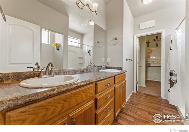 1520 Lake Vista Way, Severance, CO 80550 - full bathroom featuring double vanity, curtained shower, and wood finished floors