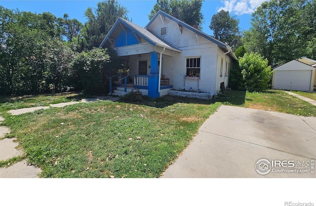 710 Carson St, Brush, CO 80723 - bungalow-style home with a porch, a front lawn, an outdoor structure, and brick siding