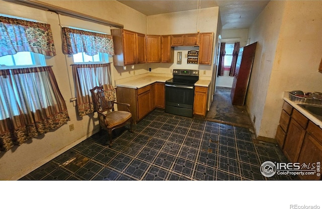 710 Carson St, Brush, CO 80723 - kitchen featuring black electric range oven, brown cabinets, light countertops, and dark floors