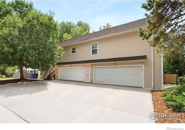 1620-1626 E 17th St, Loveland, CO 80538 - view of home's exterior with driveway, an attached garage, stairs, and a shingled roof