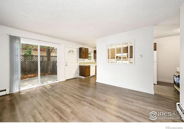 1620-1626 E 17th St, Loveland, CO 80538 - unfurnished living room with wood finished floors, a textured ceiling, and a baseboard radiator
