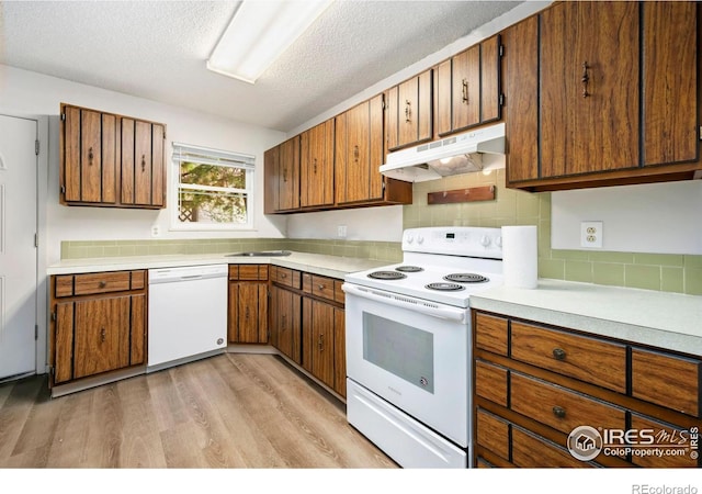 1620-1626 E 17th St, Loveland, CO 80538 - kitchen featuring white appliances, under cabinet range hood, light countertops, light wood-type flooring, and a textured ceiling