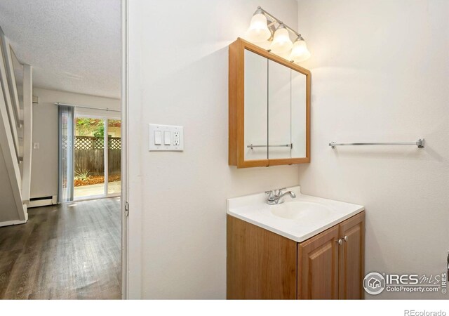 1620-1626 E 17th St, Loveland, CO 80538 - bathroom featuring vanity, baseboard heating, and wood finished floors