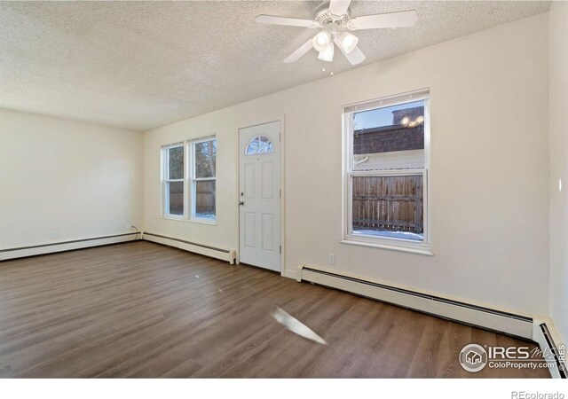1620-1626 E 17th St, Loveland, CO 80538 - entrance foyer with a baseboard heating unit, wood finished floors, a textured ceiling, and plenty of natural light