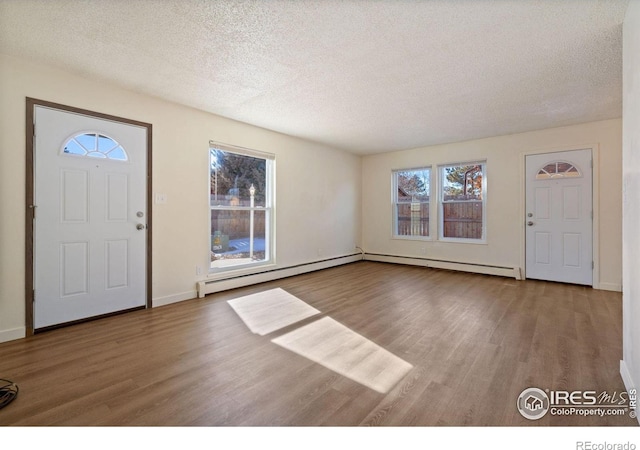 1620-1626 E 17th St, Loveland, CO 80538 - foyer entrance with plenty of natural light, wood finished floors, a textured ceiling, and baseboard heating
