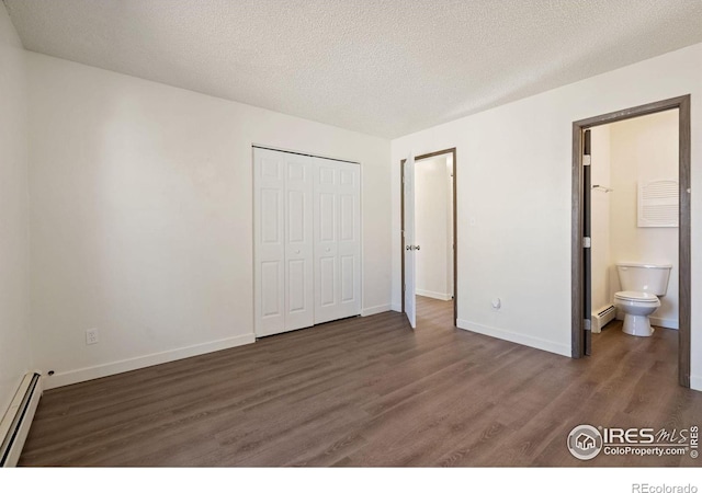 1620-1626 E 17th St, Loveland, CO 80538 - unfurnished bedroom featuring a baseboard radiator, wood finished floors, a closet, connected bathroom, and a textured ceiling