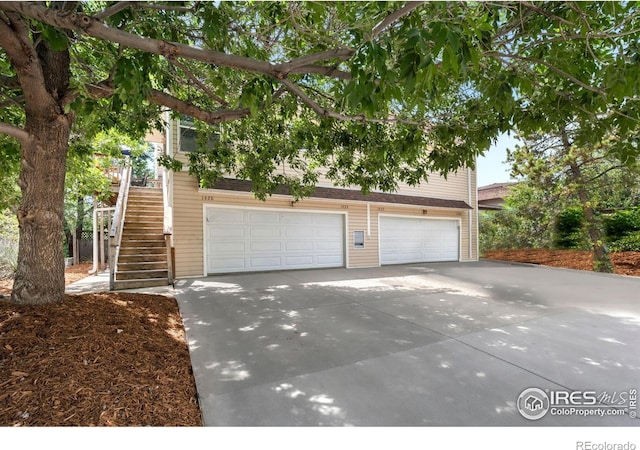 1620-1626 E 17th St, Loveland, CO 80538 - view of front of house with driveway, stairs, and a garage