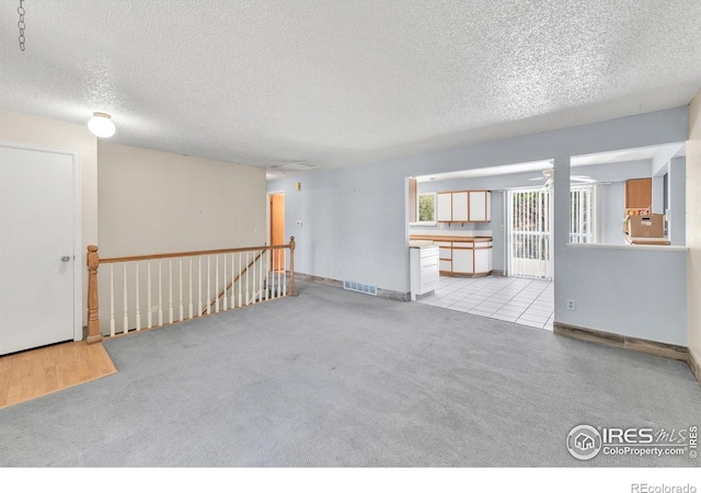 11450 Hudson St, Thornton, CO 80233 - unfurnished living room featuring a textured ceiling and light carpet