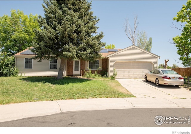 11450 Hudson St, Thornton, CO 80233 - view of front of property with concrete driveway, an attached garage, and roof mounted solar panels