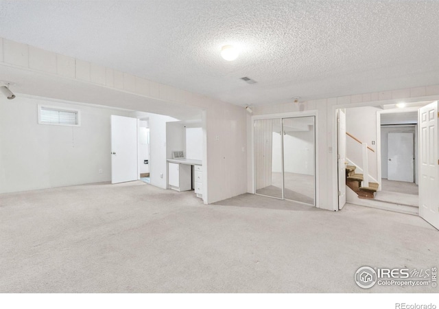 11450 Hudson St, Thornton, CO 80233 - below grade area with a textured ceiling, stairs, and light colored carpet
