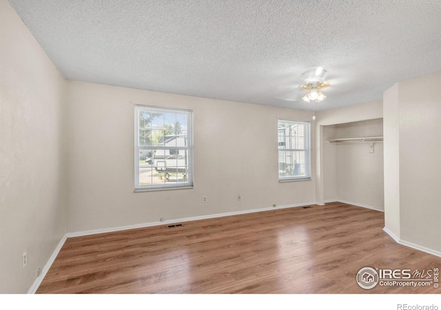 11450 Hudson St, Thornton, CO 80233 - unfurnished bedroom with wood finished floors, a textured ceiling, a closet, and a ceiling fan