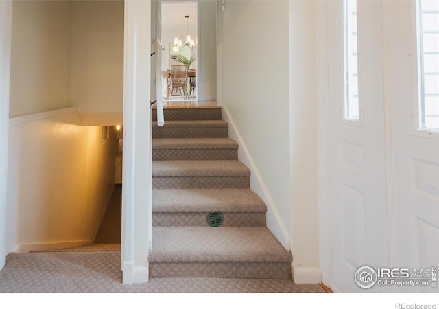 1539 Peterson St, Fort Collins, CO 80524 - staircase featuring carpet and a chandelier