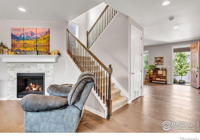 6244 Waterman Way, Frederick, CO 80516 - stairs featuring wood finished floors, recessed lighting, and a tile fireplace