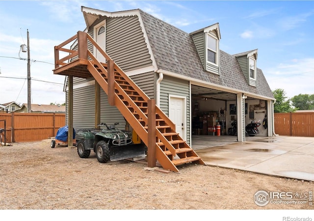 611 Elizabeth Ave, Platteville, CO 80651 - view of side of home featuring a shingled roof, stairway, a gambrel roof, concrete driveway, and a deck