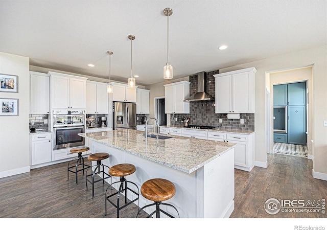 19239 W 88th Dr, Arvada, CO 80007 - kitchen with wall chimney range hood, appliances with stainless steel finishes, dark wood-type flooring, a breakfast bar area, and tasteful backsplash