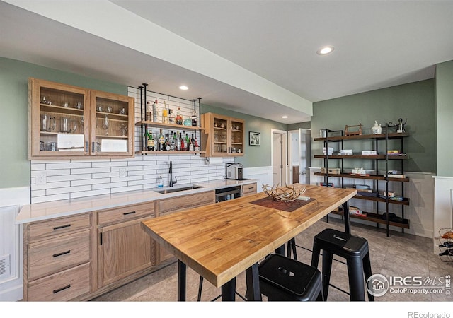 19239 W 88th Dr, Arvada, CO 80007 - kitchen with recessed lighting, light countertops, dishwasher, a wainscoted wall, and glass insert cabinets