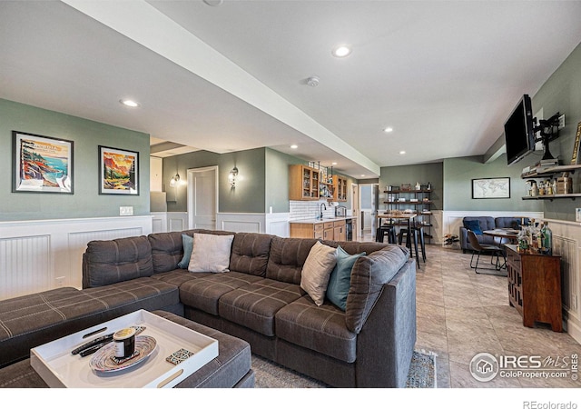 19239 W 88th Dr, Arvada, CO 80007 - living room with wainscoting, recessed lighting, a decorative wall, light tile patterned floors, and bar