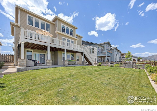 19239 W 88th Dr, Arvada, CO 80007 - back of house featuring a deck, stairway, stone siding, and a patio