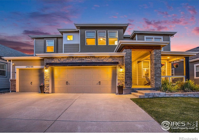 19239 W 88th Dr, Arvada, CO 80007 - prairie-style house featuring stone siding, concrete driveway, a garage, and covered porch