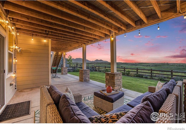 19239 W 88th Dr, Arvada, CO 80007 - patio terrace at dusk featuring outdoor lounge area, a patio area, and a fenced backyard